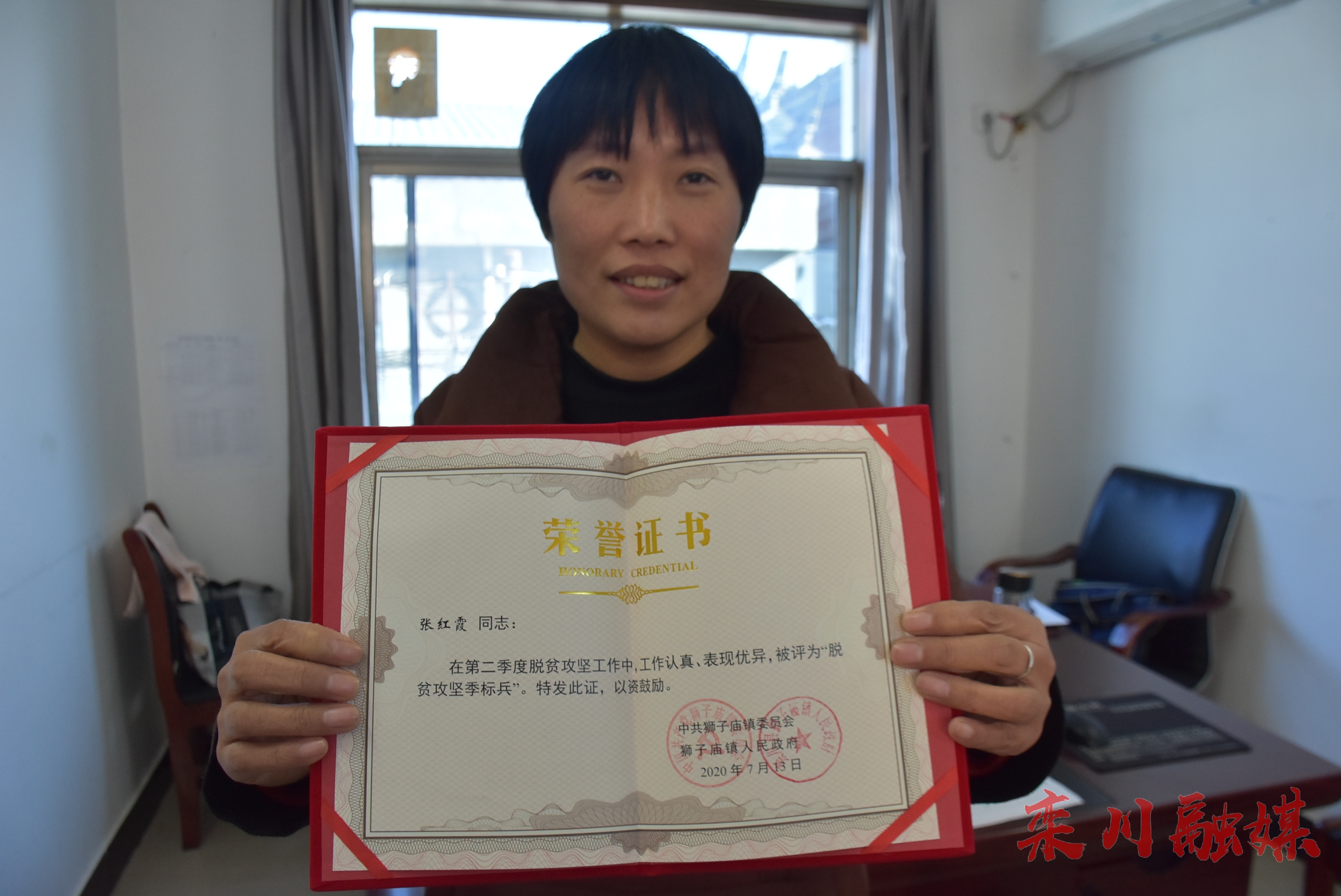 张红霞展示自己的荣誉证书.jpg
